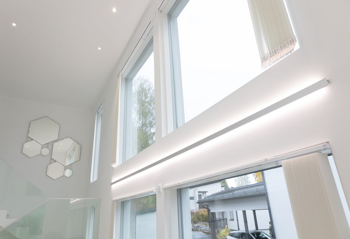 LedStore.fi-verkkokaupan tuotekuvaus: Modernissa sisustuksessa on upeat suuret ja korkeat ikkunat, ongelmat tyylikäs LED-valaistus. Tämä valaistus mahdollistaa luonnonvalon upean tulvimisen sisään. Valkoisilla seinillä on taiteellisesti aseteltu joukko kuusikulmaisia peilejä portaikon lähellä, jonka kaide on lasia. Ulkona ajotieltä löytyy pysäköityjä autoja, jotka täydentävät modernin tyylin kokonaisuutta.